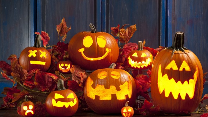Halloween carved pumpkins with autumn leaves