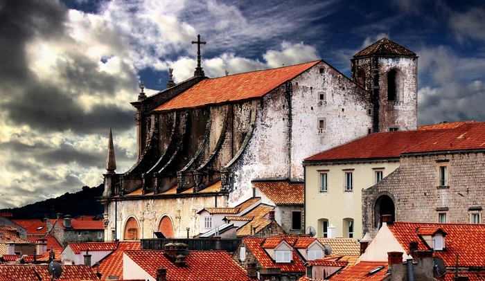 Old buildings with red roofs under a cloudy sky