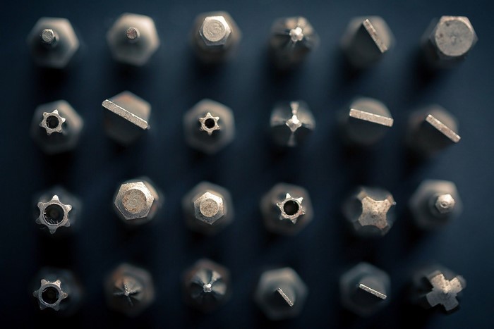Close-up of various screwdriver bits on a dark surface