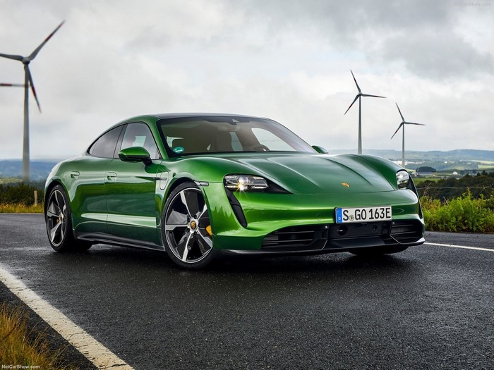 Green Porsche Taycan in a wind farm