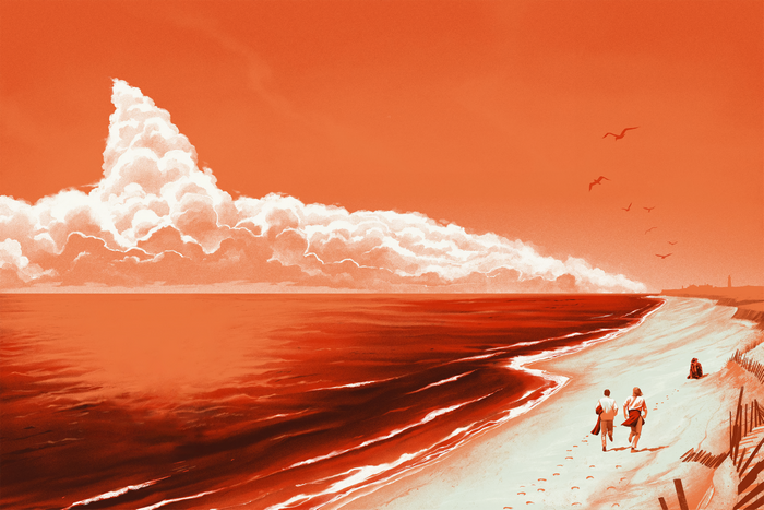 Couple walking on a beach with a large cloud formation