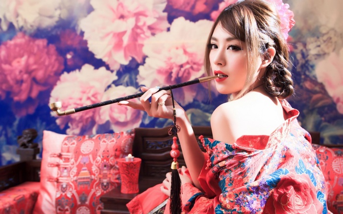 Beautiful Asian girl smoking a pipe