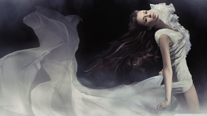 Woman with long dark hair in a white dress