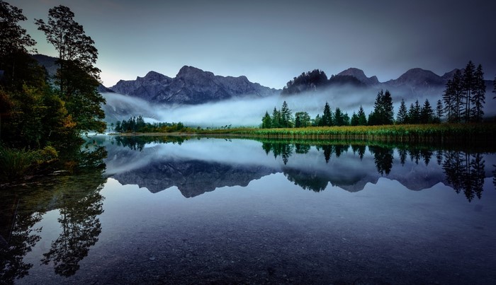 Misty Mountains Reflected in a Calm Lake in Austria