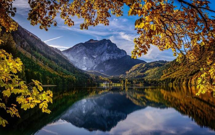 Lake reflection of mountains and autumn trees in Austria