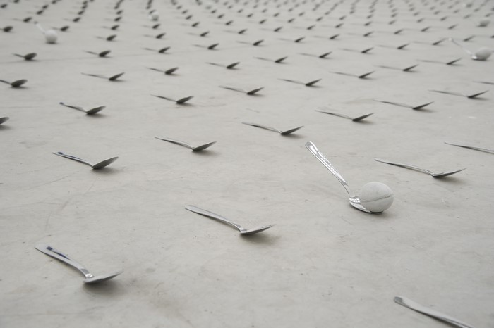 Spoons and a ball on a concrete floor