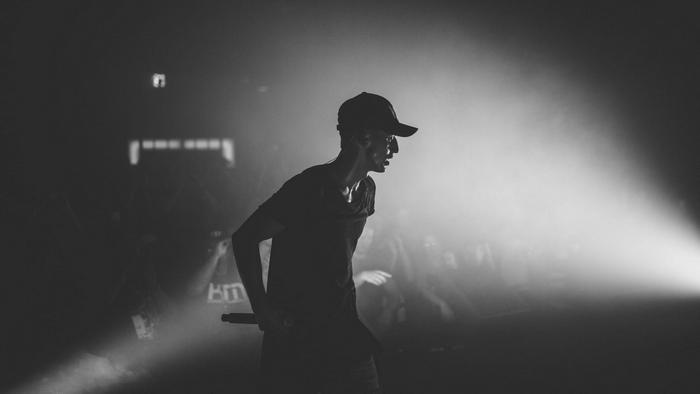 NF performing on stage with a spotlight