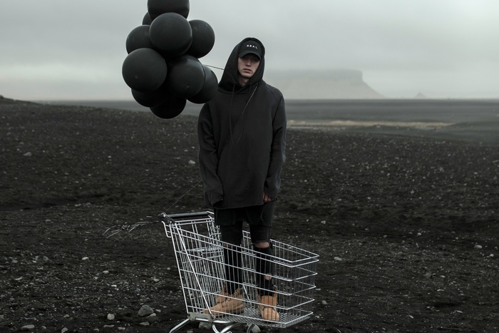 Man with black balloons in a shopping cart