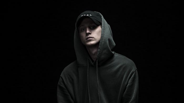 NF wearing a black baseball cap and hoodie