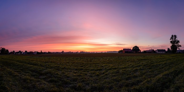 Panorama of a Polish village at sunrise with orange sky