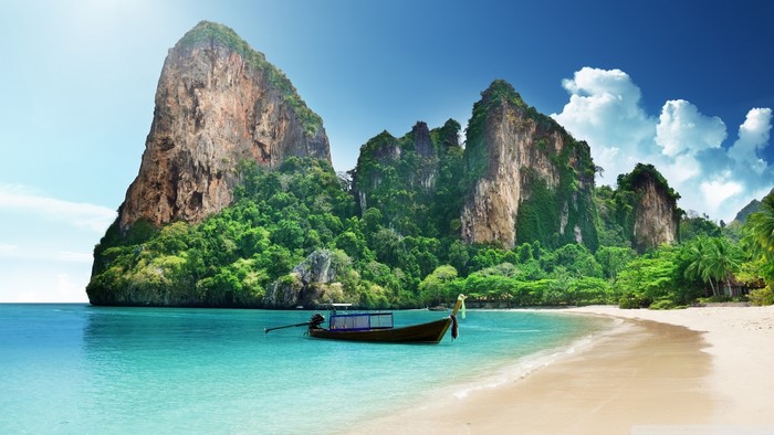 Tropical beach with limestone cliffs and a boat