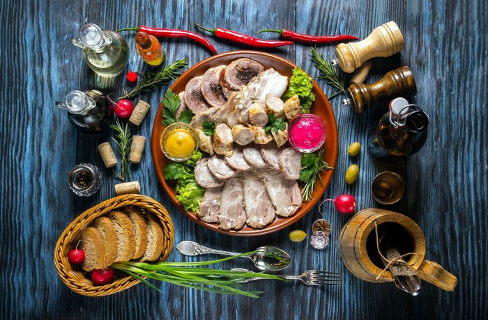 Still life with meat platter, bread, and condiments