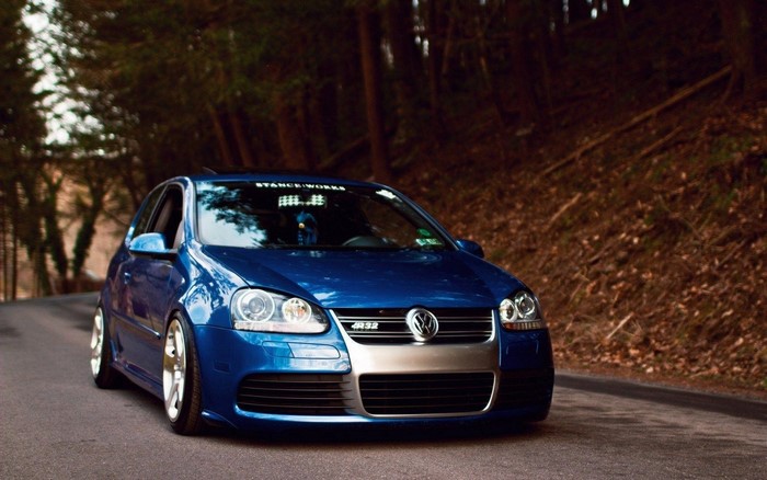Blue Volkswagen Golf R32 parked on a forest road