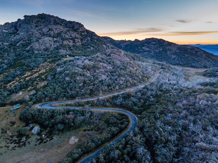 Winding mountain road through rocky terrain at sunrise
