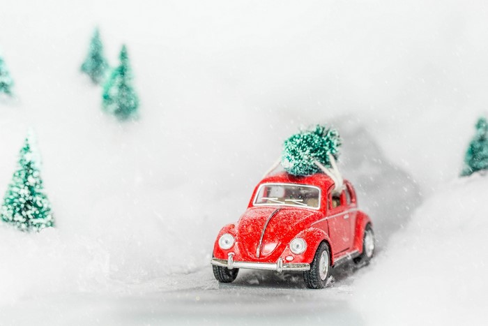 Red toy Volkswagen Beetle with Christmas tree in snow