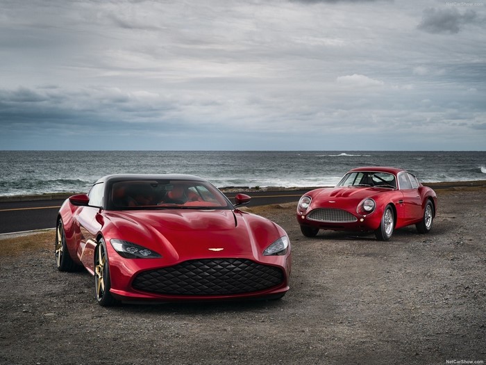 Two red Aston Martin cars by the sea