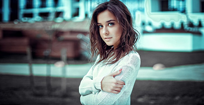 Woman with brunette hair wearing a white sweater
