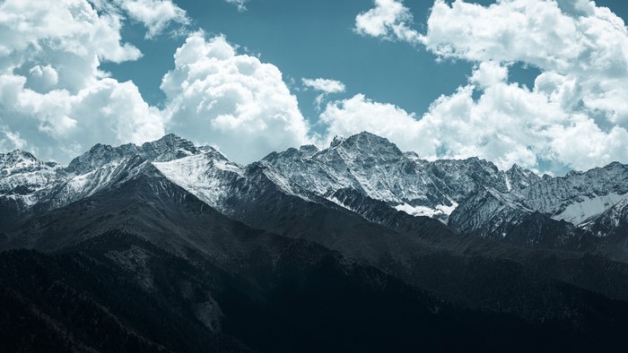 Snowy mountain range with clouds