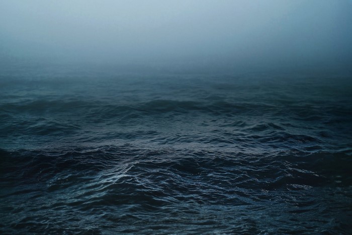 Dark ocean waves in a misty fog