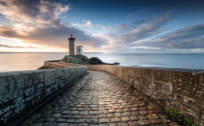 Lighthouse on a rocky outcrop with a cobblestone path