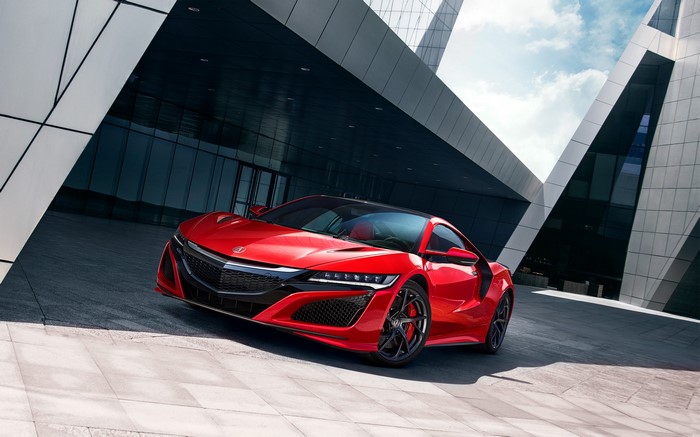 Red Acura NSX sports car parked in front of modern architecture