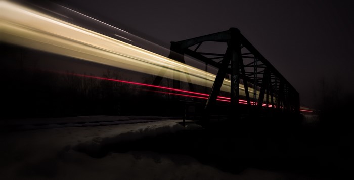 Long exposure of a train crossing a bridge at night
