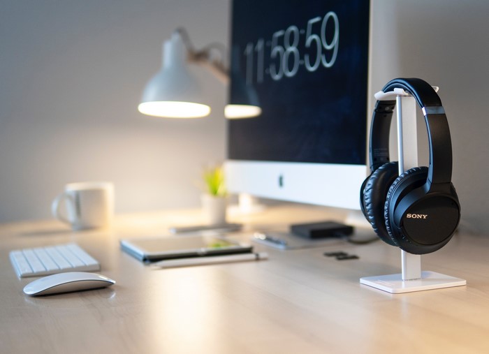 Sony headphones on a desk with a computer
