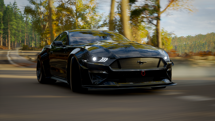 Black Ford Mustang driving on a road