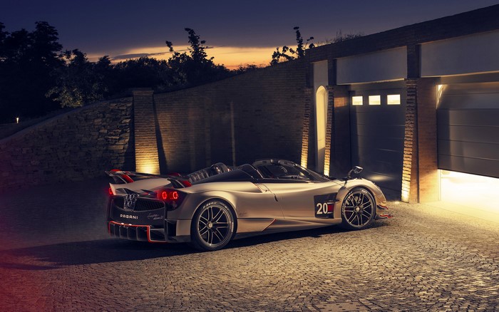 Pagani Huayra Roadster parked outside garages at dusk