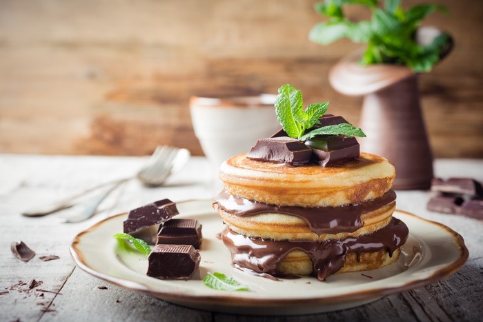 Pancakes with chocolate and mint leaves on a plate