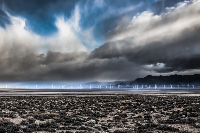 Wind turbines in a desert landscape under stormy clouds in Nevada, USA