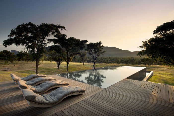 Infinity pool and lounge chairs in South Africa at sunset