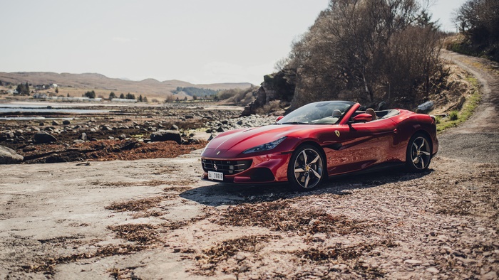 Red Ferrari Portofino M Convertible on a Rocky Shore