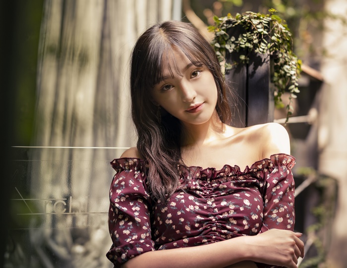 Asian woman with long brown hair wearing a floral top