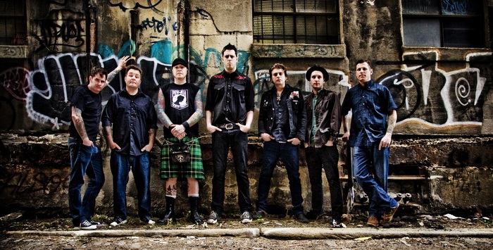 Dropkick Murphys band members posing in front of graffiti wall