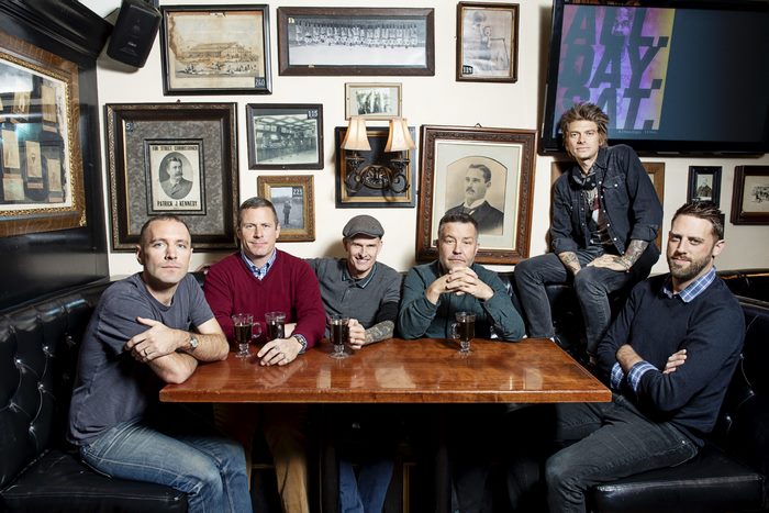 Dropkick Murphys pose for a photo in a pub