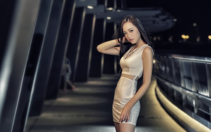 Asian woman with black hair in a white dress at night