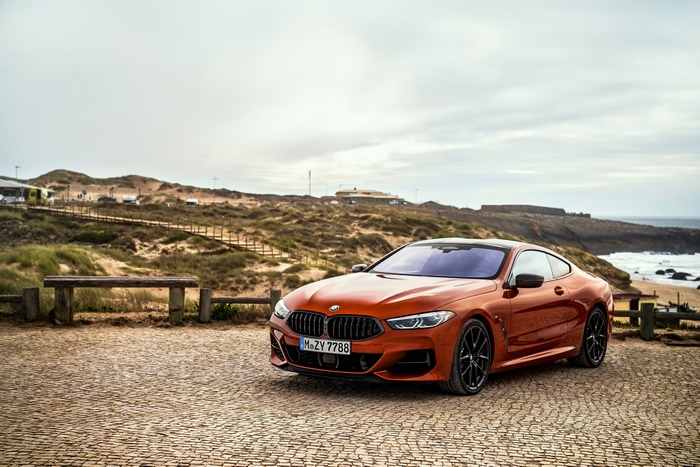 Orange BMW 8 Series Coupe on a Cobblestone Surface