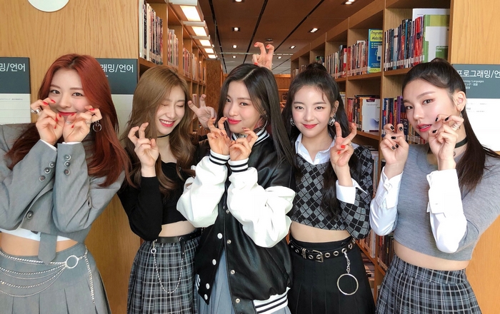 ITZY members posing in a library