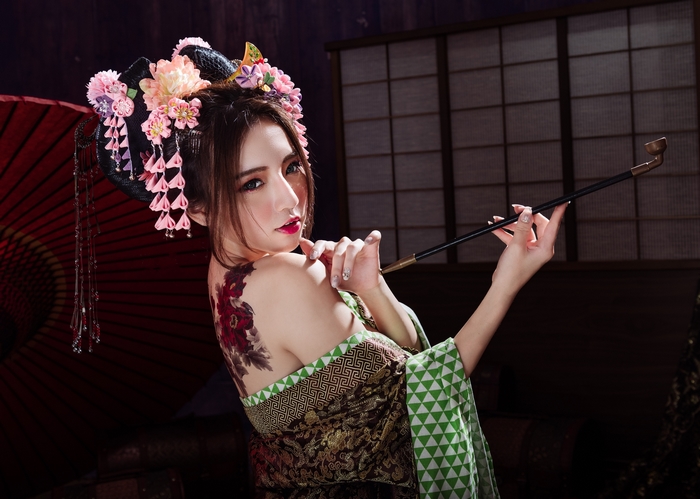 Woman with tattoo and pipe in traditional Japanese attire