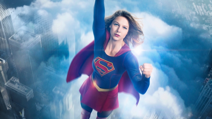 Supergirl flying over a city