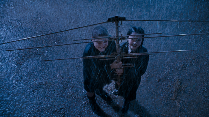 Wednesday and Pugsley Addams holding an antenna