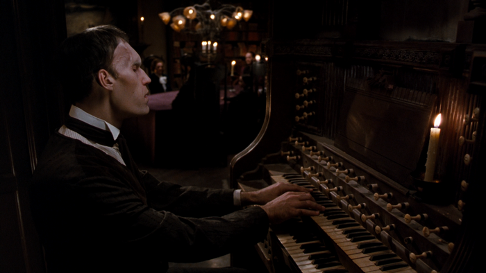 Lurch playing the organ in a dimly lit room