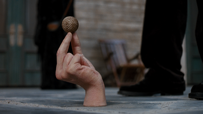 Thing from The Addams Family balances a golf ball