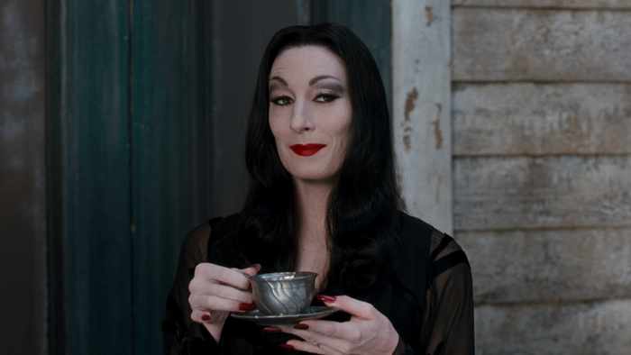 Morticia Addams holding a teacup