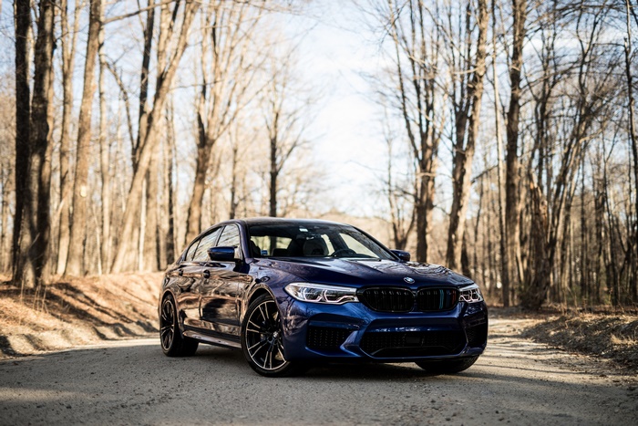 Blue BMW M5 Sedan on a Dirt Road
