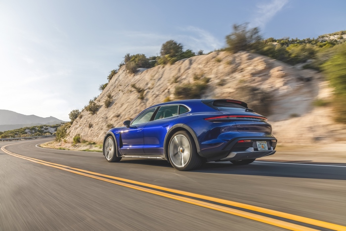 Blue Porsche Taycan Turbo S driving on a winding road