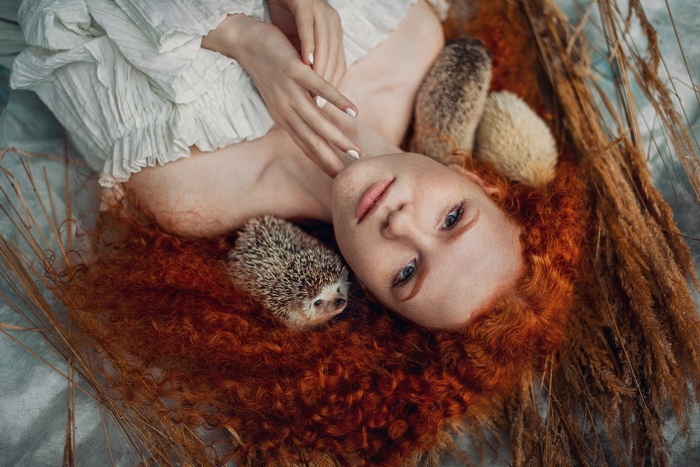 Redhead woman lying down with hedgehogs