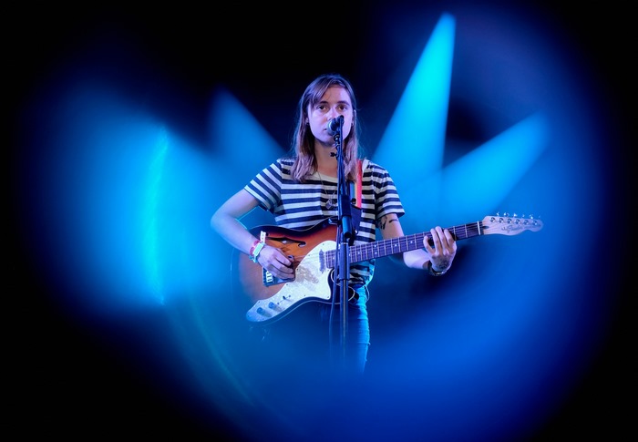 Julien Baker plays guitar on stage