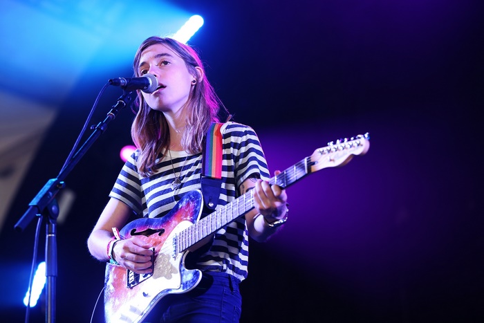 Julien Baker performs on stage with a guitar